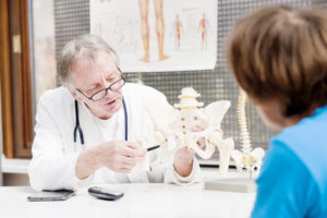 Orthopedic surgeon explaining hip replacement surgery to patient