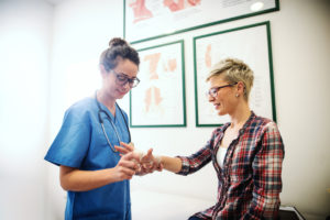 Doctor examining his female patient's wrist