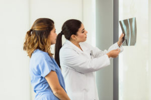 An orthopedic surgeon and a physician are discussing the results of a patient's x-ray.