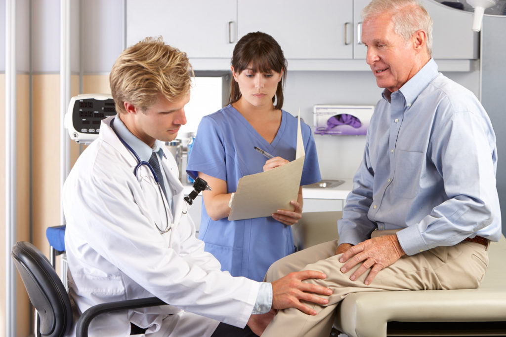 Knee Doctor examining the Patients Knee problem