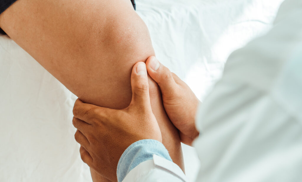 Knee Doctor examines patient's knee