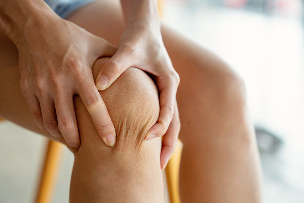 woman holding her injured knee after a meniscus tear in the knee