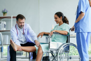 Two orthopedists assisting a patient who is on wheelchair.