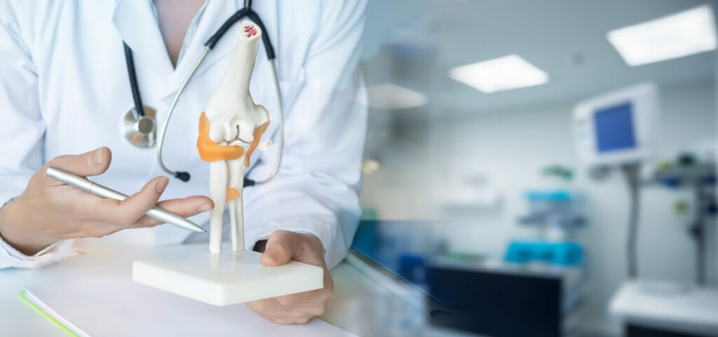 A bone doctor explains joint pain during a medical consultation.