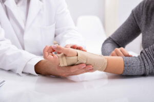 An orthopedist checked the fractured hand of a woman at the clinic.