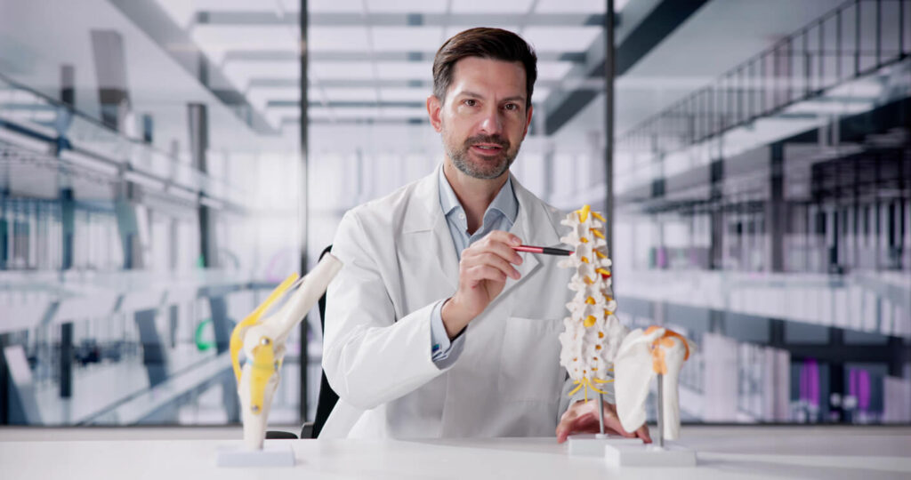 A male orthopedic physician doctor is demonstrating a skeletal joint.