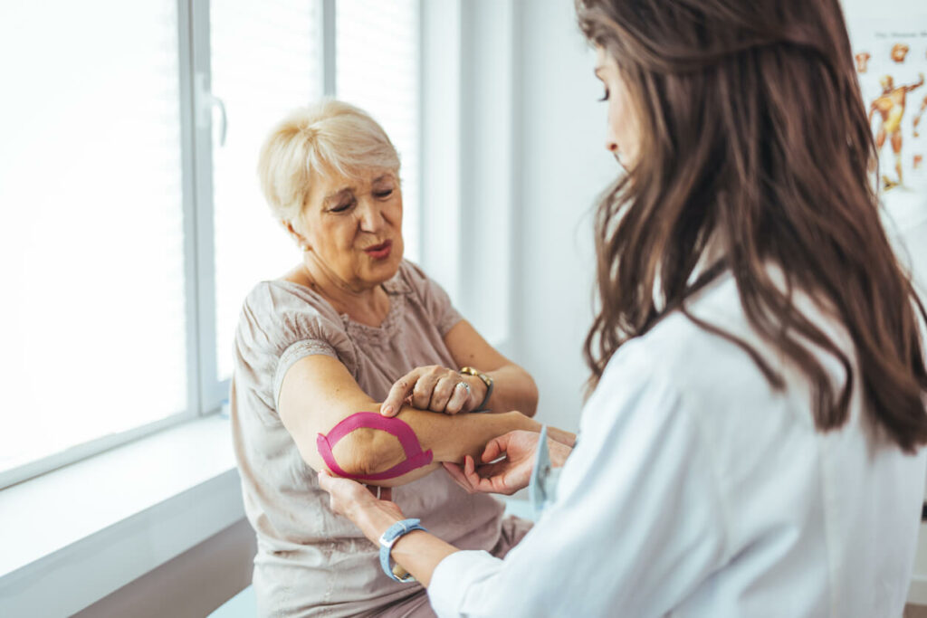 A female orthopedic surgeon is attending to a female patient who is recovering from surgery.