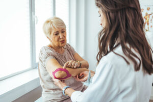 A female orthopedic surgeon is attending to a female patient who is recovering from surgery.