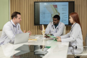 A group of orthopedists discusses a patient's knee joint 's MRI, and plan for further procedure.