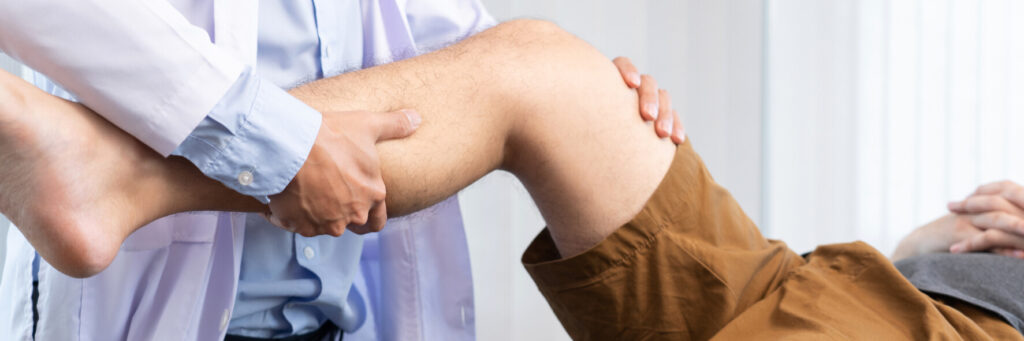 A knee doctor is examine the knee of a patient with knee pain.