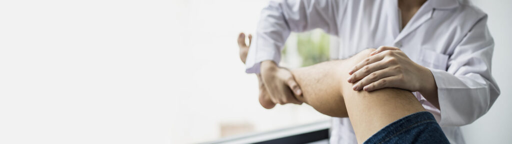 An orthopedic doctor is stretching the patient's legs.