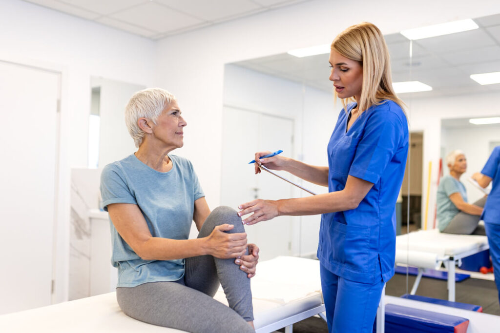 Senior Woman Discussing Knee Pain with Physiotherapist in An Orthopedic Clinic.